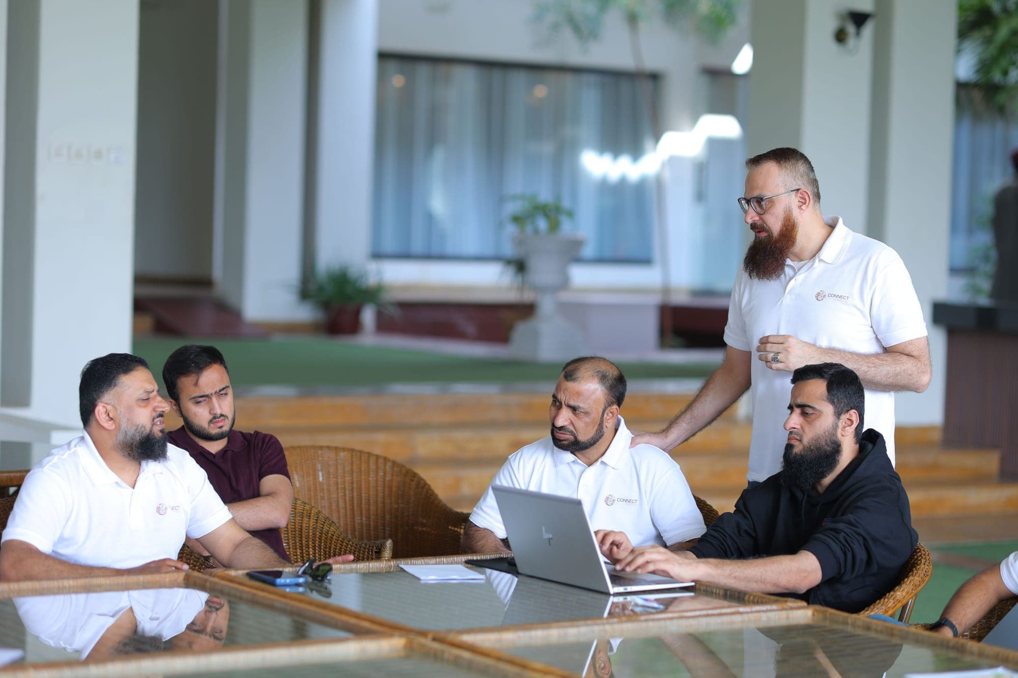 Colleagues working through a problem together at a laptop